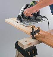 Veritas Surface Clamp clamping a board to a sawhorse while it's being cut with a circular saw