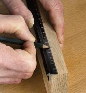 Marking wood with a pencil along the edge of a Veritas edge rule set flush with the end of the stock