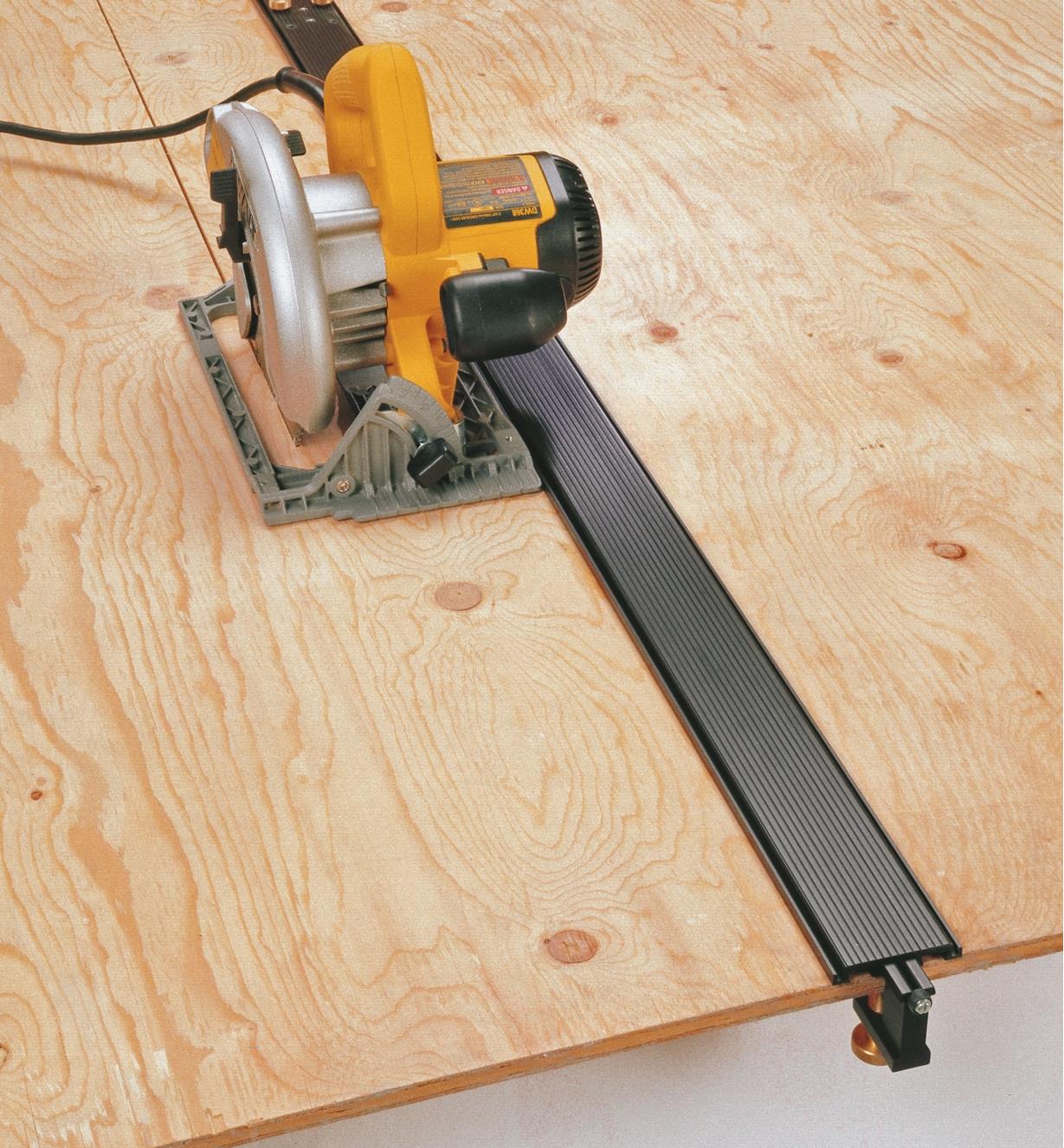100" Power Tool Guide clamped to a sheet of plywood, guiding a circular saw