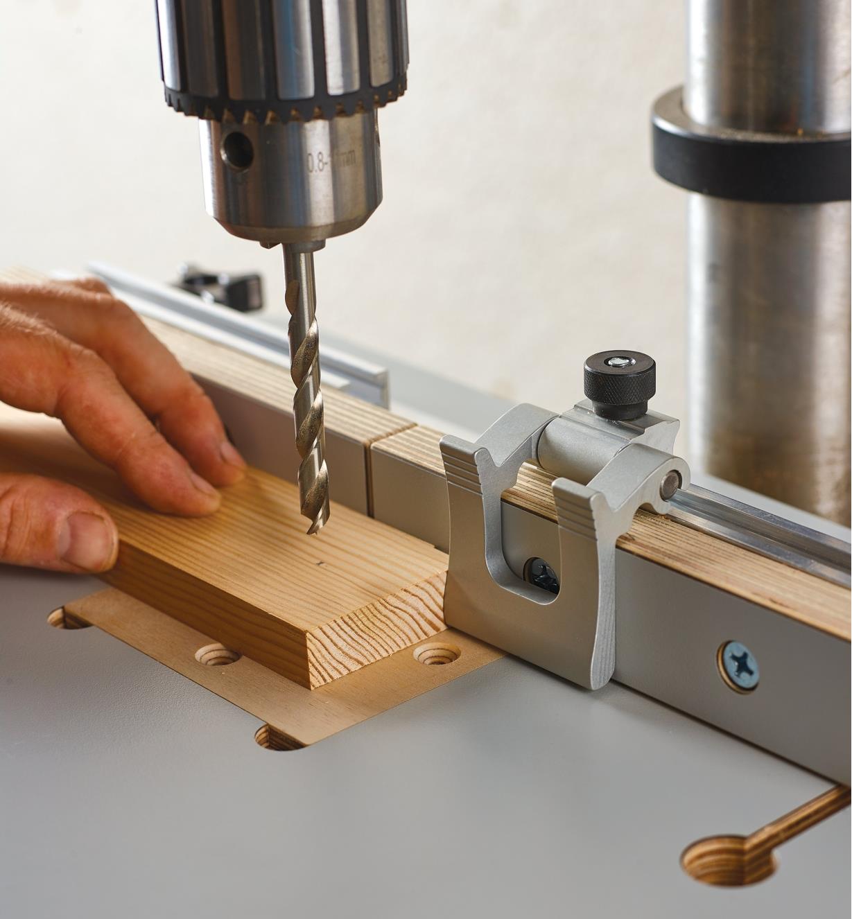A Veritas 1 1/2" flip stop mounted in the T-track on the drill-press table’s fence