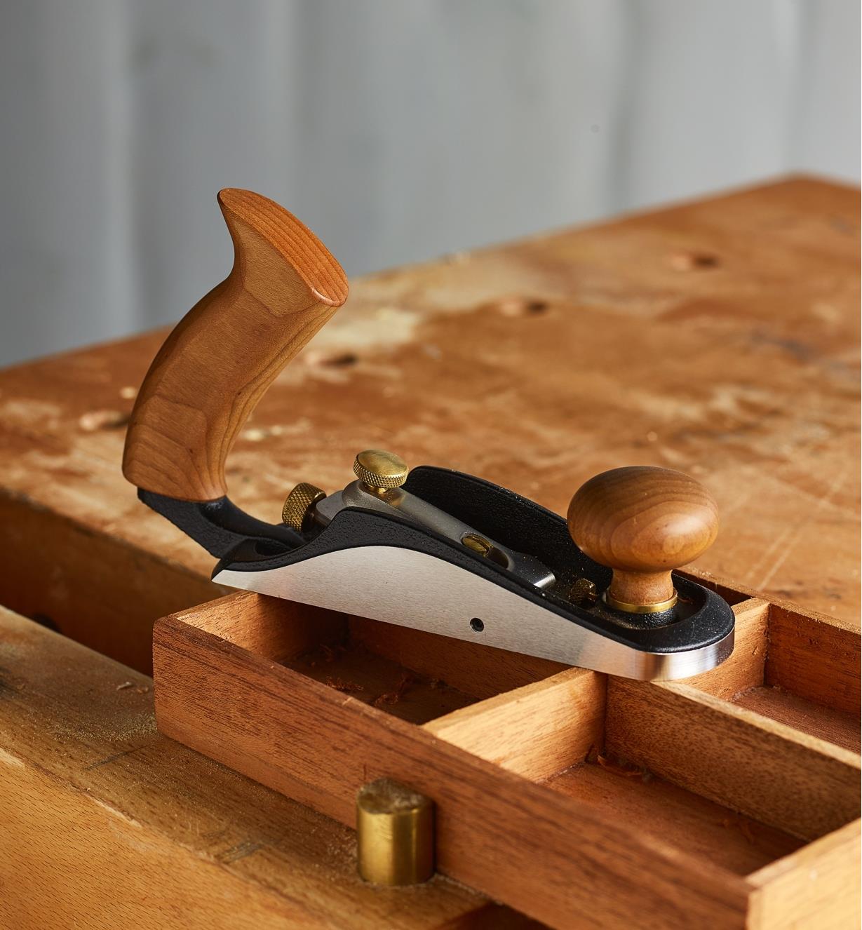 A Bevel-Up #1 Plane resting on a drawer clamped on a workbench