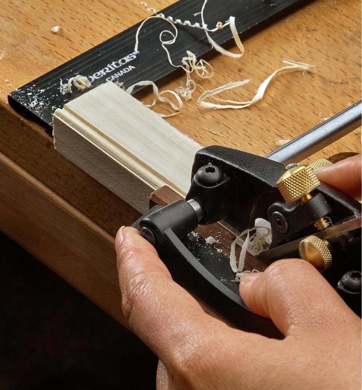 A right-hand box-maker’s plow plane being used to cut beading on the edge of a piece of wooden stock